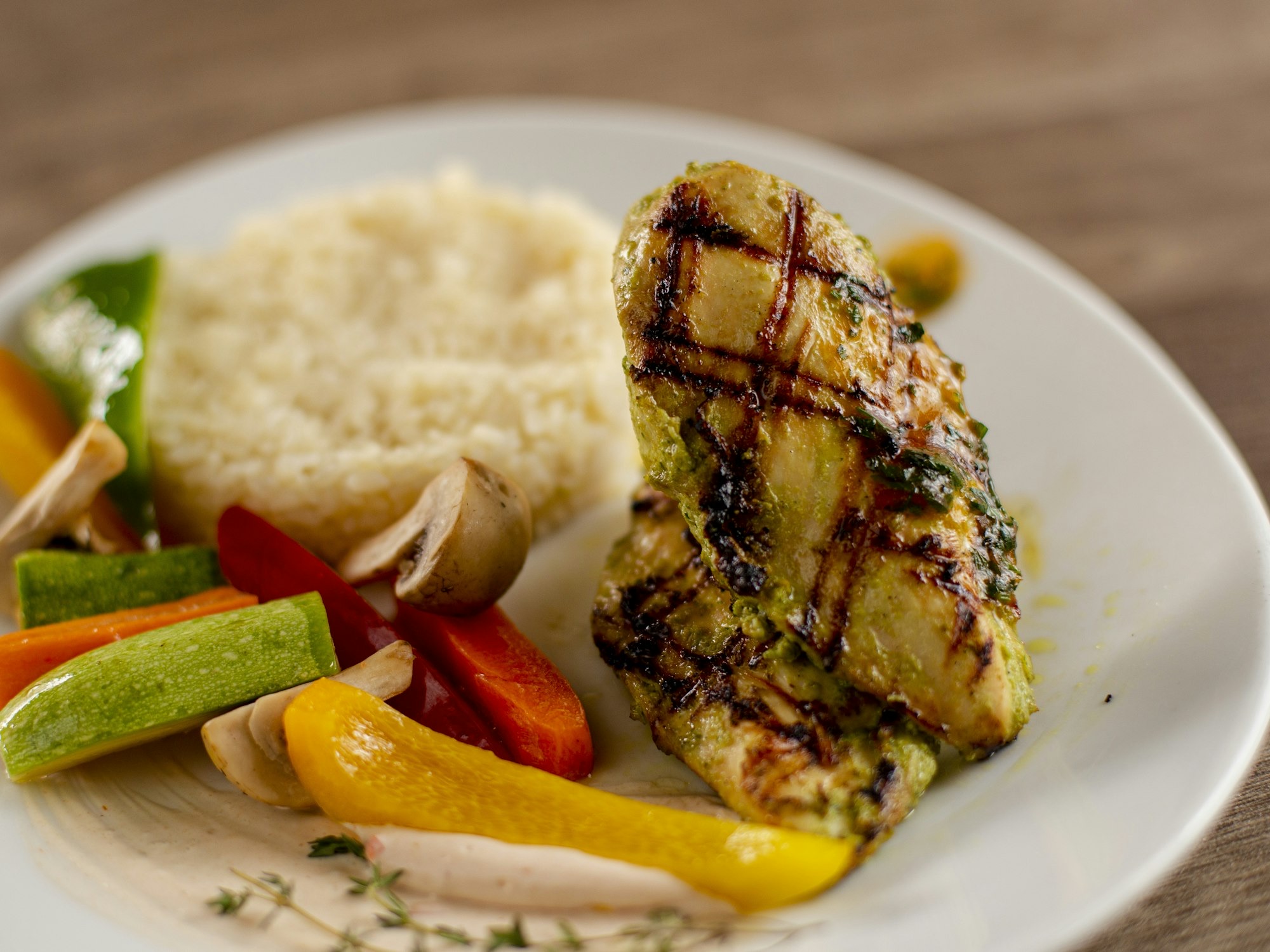 Grilled chicken breast with rice and vegetables on a plate