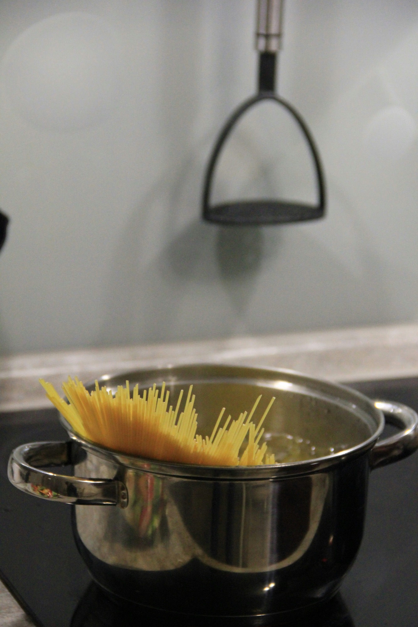 Dry spaghetti lowered into a pot of boiling water