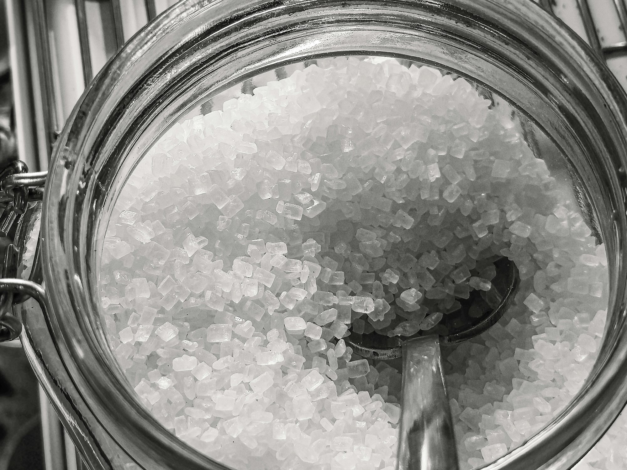 Coarse salt crystals in a glass jar with a spoon
